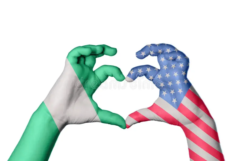 Two hands, one wrapped in the Nigerian flag and one in the American flag, shaped into a heart